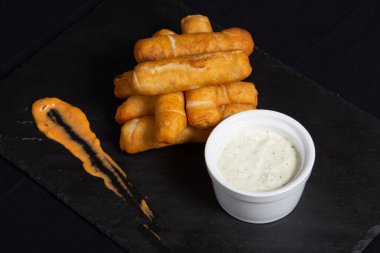 Tequenos adında, peynirle dolu kızarmış mısırdan yapılmış Latin Amerika mezeleri..