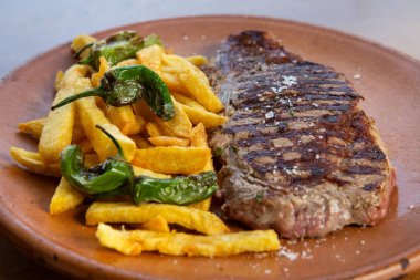 Domates ve patatesli etli biftek.