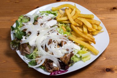 Türk mutfağı. Pomlu kebap eti patates kızartması ve tabakta salata..