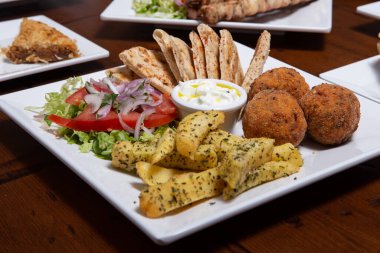 Tabakta kızarmış patates topları. Patates püresi, yumurta, un, tuz ve balkabağı tohumlarından yapılmış küçük altın toplar. Vejetaryen yemeği.