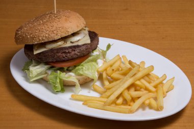 Sebzeli taze hamburger, kağıtta patates kızartması ile servis edilir..