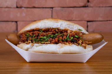 Turşulu sosis, kızarmış soğan, sos ve hardal.