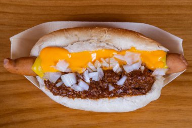 Peynirli ve soğanlı sosisli sandviçe yaklaş. Fast food.