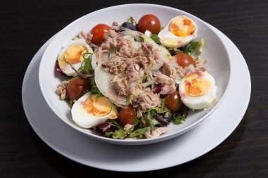 Taze sebze salatası ve beyaz tabakta ton balığı..