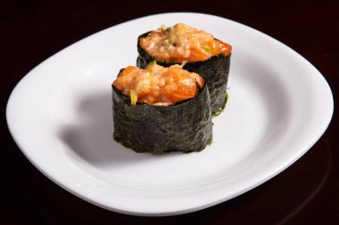 Beyaz suşi tabağında iki somon tartar.