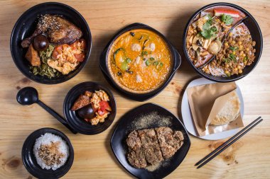 Kırmızı zemin üzerinde geleneksel Çin mutfağından çeşitli yemekler: pilavlı tatlı ve ekşi tavuk, bambu buharlı börek, kızarmış ekmek, karidesli erişte. Asya gıda konsepti, üst görünüm .