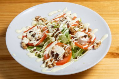 Peynirli salata, fındık ve taze sebze. Ahşap bir arka planda