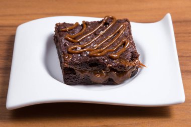 Dikdörtgen beyaz tabakta servis edilen çikolatalı kek.