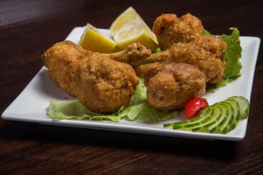 Tahtada limon olan kızarmış tavuk budu.