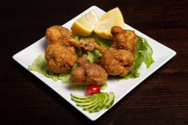 Tahtada limon olan kızarmış tavuk budu.