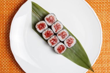 Sake maki Japon suşisi beyaz tabakta ton balıklı rulo.