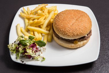 Sebzeli taze burger ve ahşap bir arka planda patates kızartması..