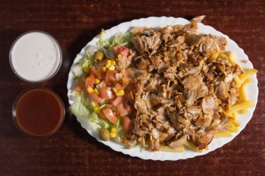 Tabağında patates kızartması olan bir fast food kebabı..