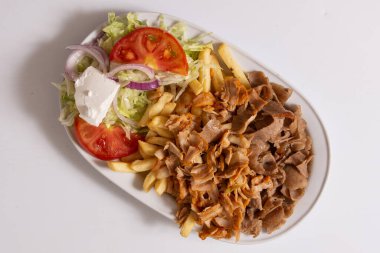 Tabağında patates kızartması olan bir fast food kebabı..
