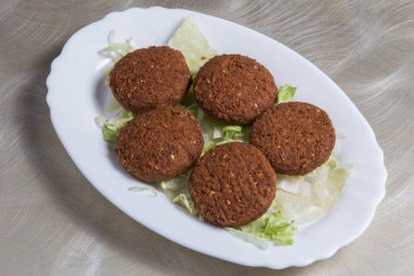 Falafel, nilüfer yaprağı beyaz bir tabakta salata ile dolu.