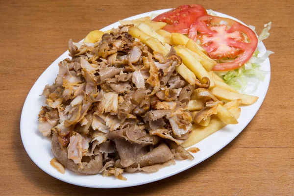 Tabağında patates kızartması olan bir fast food kebabı..