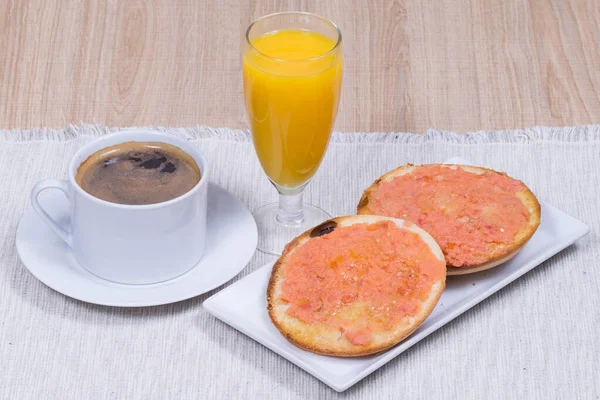 Typcal spanish breakfast, coffee and toast with olive oil and grinded natural tomato.