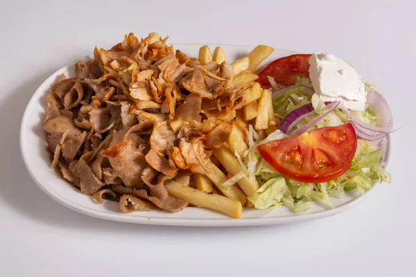 Tabağında patates kızartması olan bir fast food kebabı..