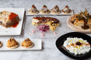 Geleneksel Yunan yemeği seçimi - salata, meze, turta, balık, tzatziki, taş zeminde dolma. Tabak, paylaş.