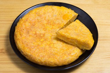 Beyaz tabakta yumurtalı ve patatesli omlet. İspanyol omleti - Geleneksel tortilla tapas de patatas