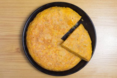 Beyaz tabakta yumurtalı ve patatesli omlet. İspanyol omleti - Geleneksel tortilla tapas de patatas