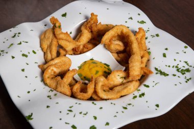 Çıtır tavuk kızartması ve beyaz tabakta sos.