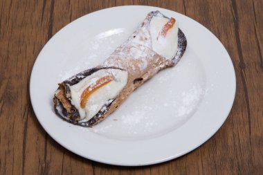 Sicilya 'dan beyaz bir tabakta tek bir tatlı cannolo