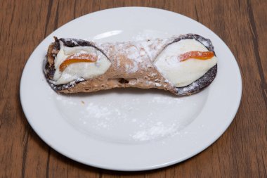 Sicilya 'dan beyaz bir tabakta tek bir tatlı cannolo