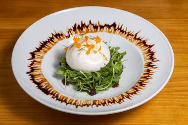 Beyaz tabakta salata karışımı lezzetli taze buratta.