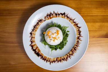 Beyaz tabakta salata karışımı lezzetli taze buratta.