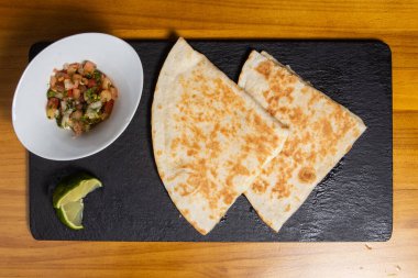 Peynir, domates ve marulla dolu lezzetli bir quesadilla..