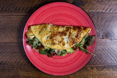 Mantarlı, avokadolu ve roka aromalı kırsal omlet.