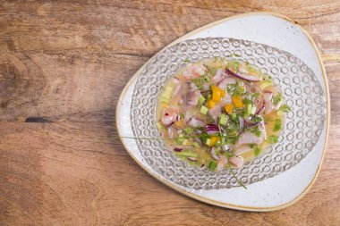 Yakın plan deniz levreği ceviche cam kase ahşap arka planda servis edilir. Taze ve lezzetli ceviche. Çiğ balık. Latin Amerika mutfağı.