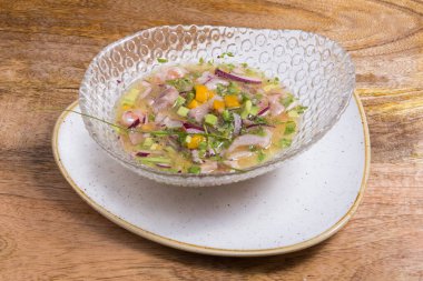 Yakın plan deniz levreği ceviche cam kase ahşap arka planda servis edilir. Taze ve lezzetli ceviche. Çiğ balık. Latin Amerika mutfağı.