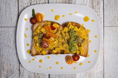 Somon, sebze, guacamole sosu ve domatesli tost.