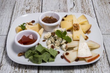 Tahta bir kutuda bir peynir seti. Parmesan, Mamsam, Mozzarella, Brie, Feta.