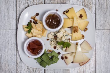 Tahta bir kutuda bir peynir seti. Parmesan, Mamsam, Mozzarella, Brie, Feta.