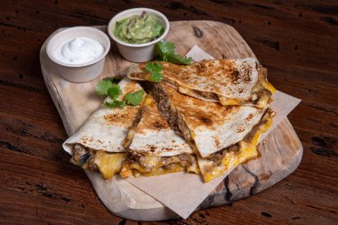 Peynir ve sosla dolu lezzetli bir quesadilla.