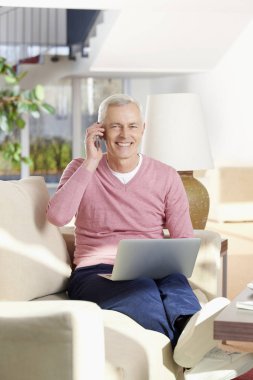 Dizüstü bilgisayar kullanan kıdemli adam.