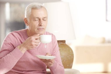 yaşlı adam kanepede çay içme
