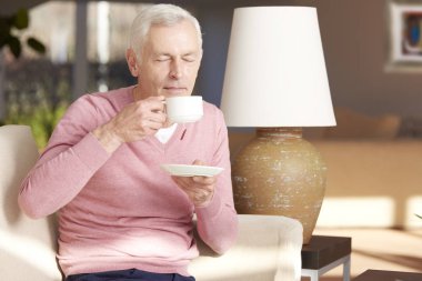 yaşlı adam kanepede çay içme