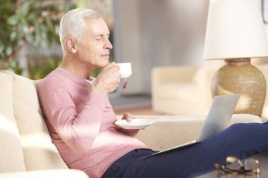 yaşlı adam kanepede çay içme