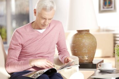 Son sınıf öğrencisi evde kitap okuyor.