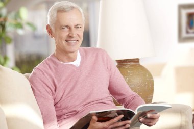 Kanepede kitap okuyan adam.