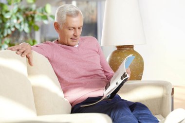 Kanepede kitap okuyan adam.