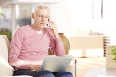 Dizüstü bilgisayar kullanan kıdemli adam.