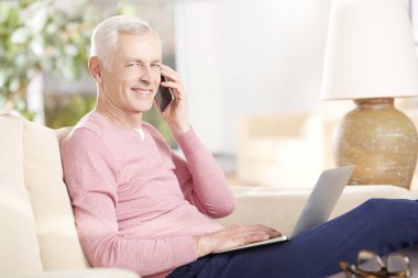 Dizüstü bilgisayar kullanan kıdemli adam.