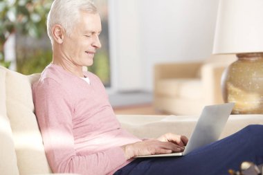 Dizüstü bilgisayar kullanan kıdemli adam.