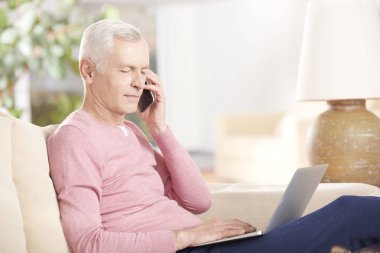 Dizüstü bilgisayar kullanan kıdemli adam.