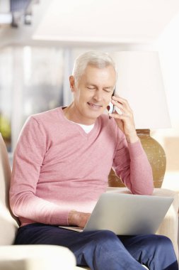 Dizüstü bilgisayar kullanan kıdemli adam.